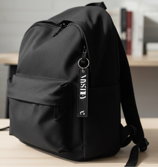Black backpack with a MYSTIFY tag on a wooden surface.